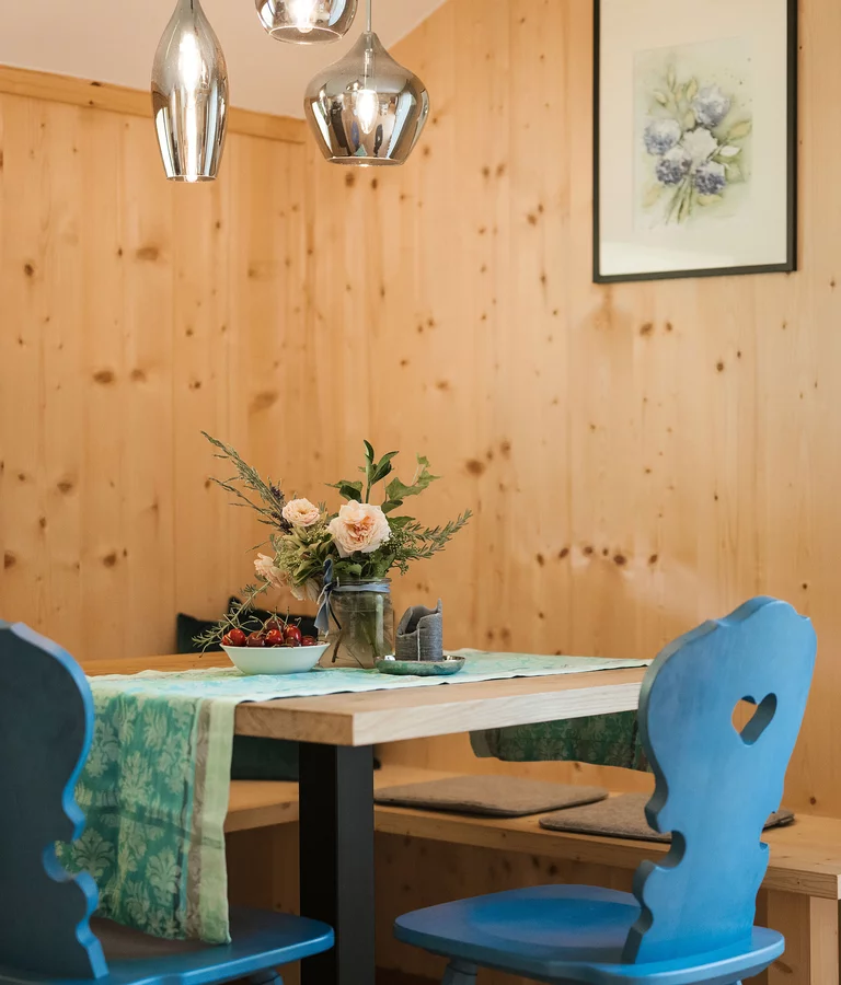 Sitzecke in Holz mit blauen Holzstühlen, moderne Lampen.