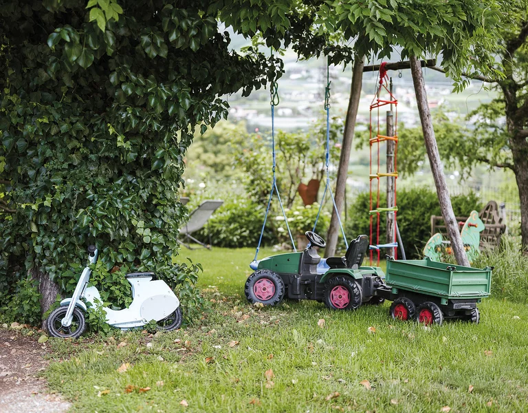 Kinderspielplatz im Grünen mit Tratroller und Holzvespa, Uralub am Bauernhof.