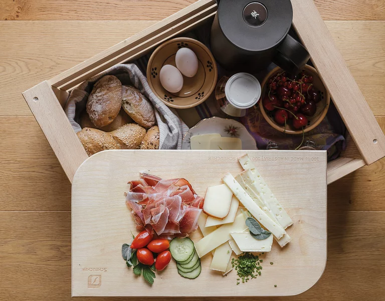 Frühstück in der Holzkiste, Wurst, Käse, Hühnereier, Brot, Obst und Gemüse.