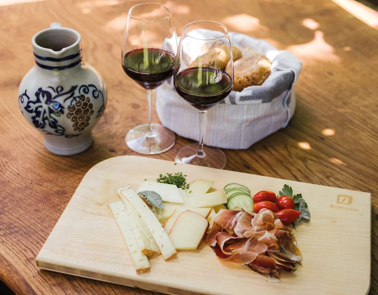 Marende Bauernhof Frühstück Holztisch mit Südtiroler Marende, Speck, Käse, Schüttelbrot und Rotwein.